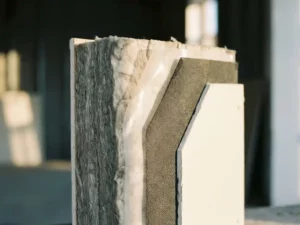 Doorsnede van moderne wandopbouw met dampremmen tussen isolatie en gipsplaat, warme zijverlichting toont materiaalstructuren